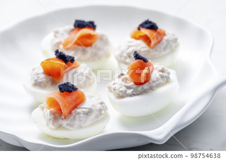 boiled eggs filled with tuna fish spread and smoked salmon and black caviar on the top boiled eggs filled with tuna fish spread and smoked salmon and black caviar on the top 98754638