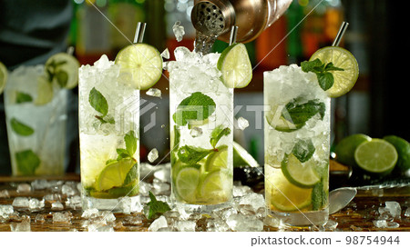 Preparation of mojito drinks on bar counter. 98754944