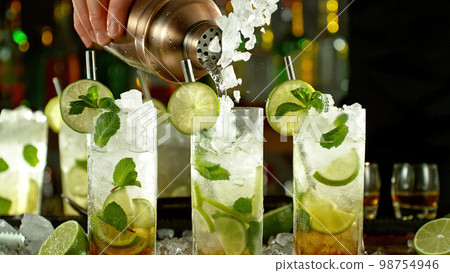 Preparation of mojito drinks on bar counter. 98754946