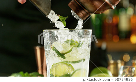 Preparation of mojito drink on bar counter. 98754956