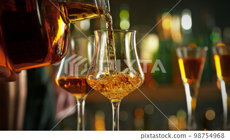 Detail of pouring rum into glass. Detail of pouring rum into glass. 98754968