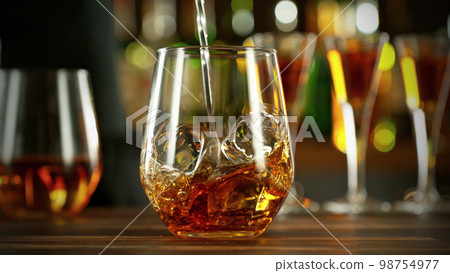 Detail of stiring whiskey glass with ice. Detail of stiring whiskey glass with ice. 98754977