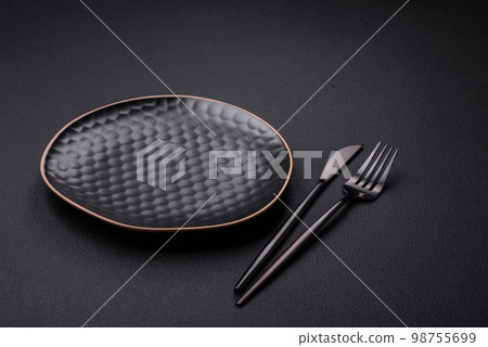 Empty ceramic round plate on dark textured concrete background Empty ceramic round plate on dark textured concrete background 98755699