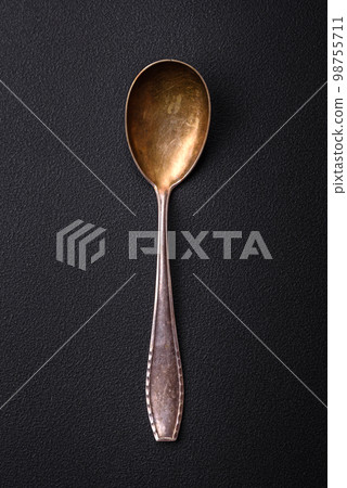 Empty metal spoon on dark textured concrete background 98755711