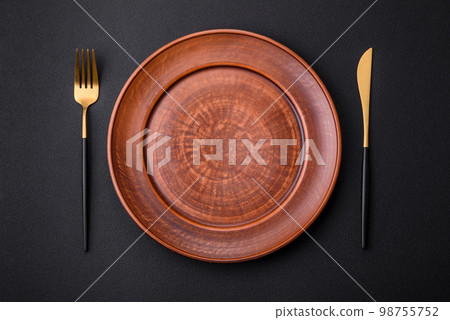 Empty ceramic round plate on dark textured concrete background Empty ceramic round plate on dark textured concrete background 98755752