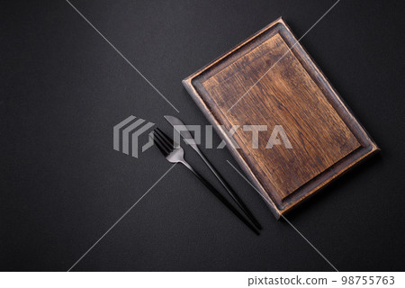 Empty wooden cutting board on dark textured concrete background 98755763
