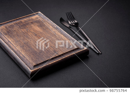 Empty wooden cutting board on dark textured concrete background 98755764