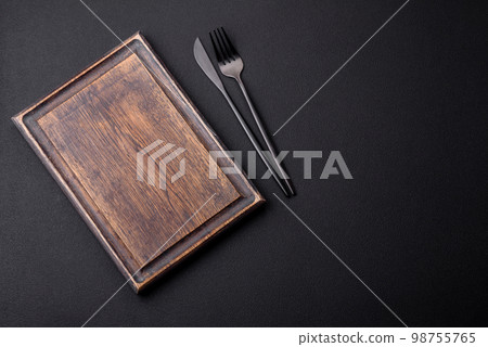 Empty wooden cutting board on dark textured concrete background 98755765