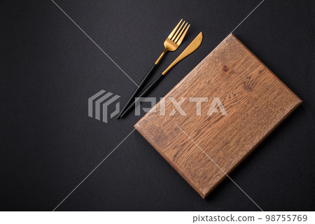Empty wooden cutting board on dark textured concrete background 98755769