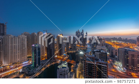 Panorama of various skyscrapers in tallest recidential block in Dubai Marina aerial night to day 98757271