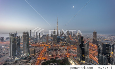 Aerial view of tallest towers in Dubai Downtown skyline and highway night to day . Aerial view of tallest towers in Dubai Downtown skyline and highway night to day . 98757321