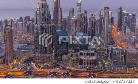 Aerial view of tallest towers in Dubai Downtown skyline and highway night to day . 98757327
