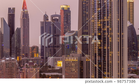 Row of the tall buildings around Sheikh Zayed Road and DIFC district aerial day to night in Dubai Row of the tall buildings around Sheikh Zayed Road and DIFC district aerial day to night in Dubai 98757386