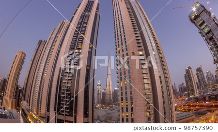 Tallest skyscrapers in downtown dubai located on bouleward street near shopping mall aerial night to day . Tallest skyscrapers in downtown dubai located on bouleward street near shopping mall aerial night to day . 98757390