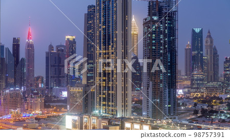 Row of the tall buildings around Sheikh Zayed Road and DIFC district aerial day to night in Dubai Row of the tall buildings around Sheikh Zayed Road and DIFC district aerial day to night in Dubai 98757391