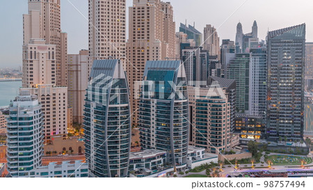 Dubai Marina skyscrapers and JBR district with luxury buildings and resorts aerial night to day Dubai Marina skyscrapers and JBR district with luxury buildings and resorts aerial night to day 98757494