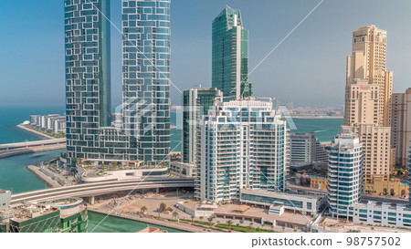 Promenade and canal seen from Dubai marina . Aerial view to JBR district and Bluewaters Island behind Promenade and canal seen from Dubai marina . Aerial view to JBR district and Bluewaters Island behind 98757502