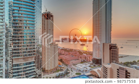 Panoramic sunset view of the Dubai Marina and JBR area and the famous Ferris Wheel aerial 98757558