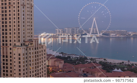 Bluewaters island with modern architecture and ferris wheel aerial night to day . Bluewaters island with modern architecture and ferris wheel aerial night to day . 98757562