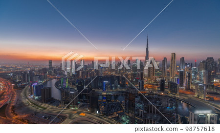 Skyline with modern architecture of Dubai business bay towers day to night . Aerial view Skyline with modern architecture of Dubai business bay towers day to night . Aerial view 98757618
