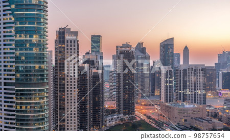 Dubai's business bay towers aerial day to night . Rooftop view of some skyscrapers Dubai's business bay towers aerial day to night . Rooftop view of some skyscrapers 98757654