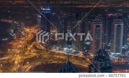 JLT and Dubai marina skyscrapers near Sheikh Zayed Road aerial all night . Residential buildings 98757761