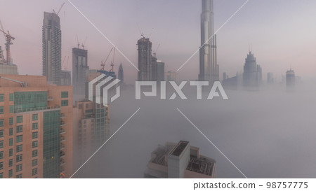 Aerial view of Dubai city early morning during fog night to day . Aerial view of Dubai city early morning during fog night to day . 98757775
