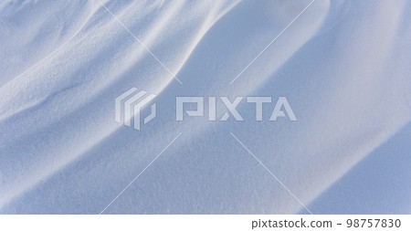Snowdrift waves in sunset light, winter background of snow waves Snowdrift waves in sunset light, winter background of snow waves 98757830