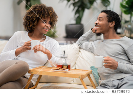 Positive black lovers enjoying tea at home 98759973