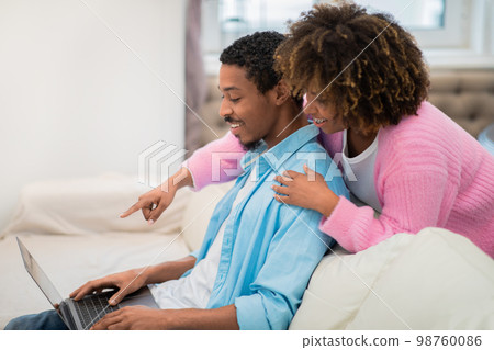 Loving african american young couple shopping on Internet at home Loving african american young couple shopping on Internet at home 98760086