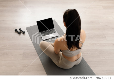 High angle view long-haired athletic woman using laptop 98760225