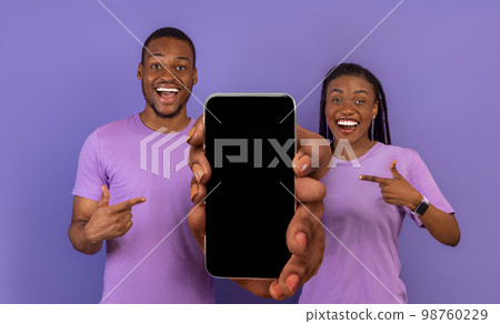 Online Offer. Positive African American Couple Pointing At Smartphone With Blank Screen Online Offer. Positive African American Couple Pointing At Smartphone With Blank Screen 98760229
