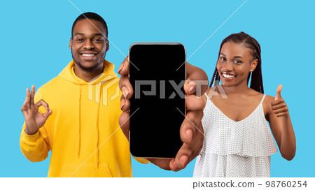 Great Offer. Young African American Couple Demonstrating Big Blank Smartphone At Camera 98760254