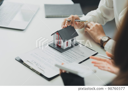 Banker or Agent calculate price for buy or loan house and showing to customer. Real Estate concept. Banker or Agent calculate price for buy or loan house and showing to customer. Real Estate concept. 98760377
