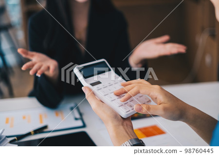 Asian Business Woman or Accountant do math and analyze with calculator and paperwork on desk, account, consult, audit and saving concept. 98760445