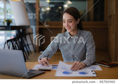 Asian Business Woman or Accountant with paperwork on desk, account, Financial Online Class concept Asian Business Woman or Accountant with paperwork on desk, account, Financial Online Class concept 98760460