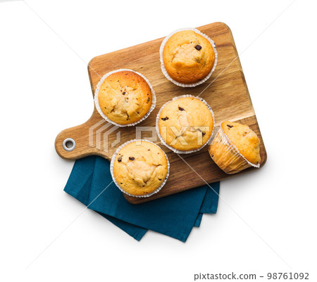 Sweet vanilla muffins on cutting board isolated on white background. 98761092