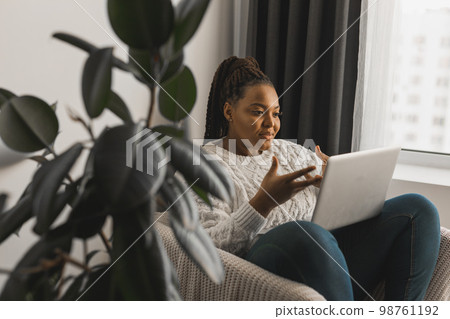 African american woman making video call in living room - social networks and connection 98761192
