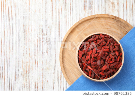 Dried goji berries in bowl on white wooden table, flat lay. Space for text Dried goji berries in bowl on white wooden table, flat lay. Space for text 98761385