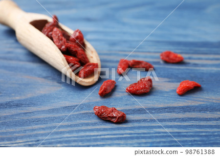 Dried goji berries on blue wooden table, closeup Dried goji berries on blue wooden table, closeup 98761388