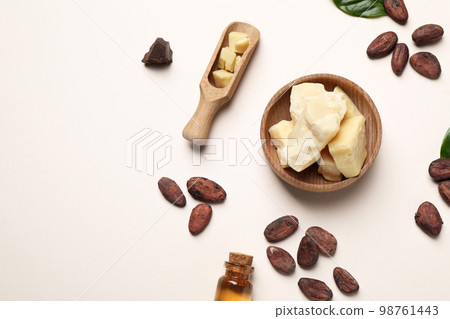 Organic cocoa butter, beans and essential oil on beige background, flat lay 98761443