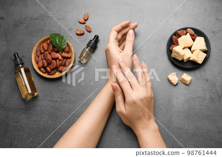 Woman applying organic cocoa butter at table, top view 98761444
