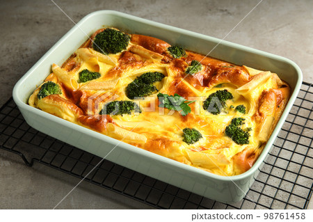 Tasty broccoli casserole in baking dish on cooling rack 98761458