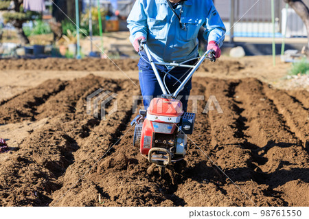 一個用小中耕機耕種菜園的人 一個用小中耕機耕種菜園的人 98761550
