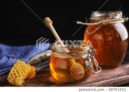 Jar of sweet honey on wooden board 98761852