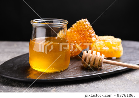 Tasty aromatic honey and combs on grey table 98761863