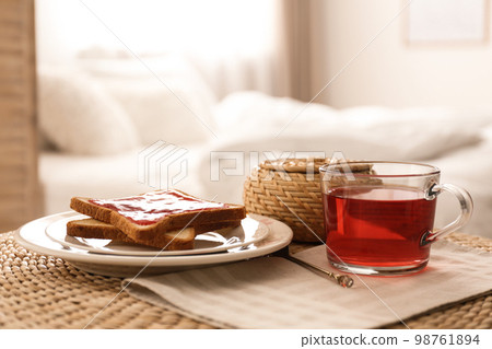 Toasts and tea on table indoors. Delicious morning meal Toasts and tea on table indoors. Delicious morning meal 98761894