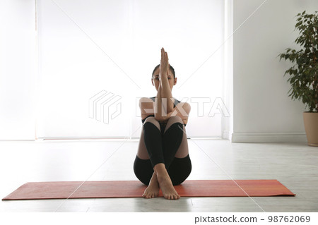 Woman practicing eagle asana in yoga studio. Garudasana pose 98762069
