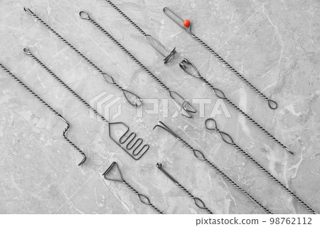 Set of different logopedic probes on marble table, flat lay. Speech therapist's tools Set of different logopedic probes on marble table, flat lay. Speech therapist's tools 98762112
