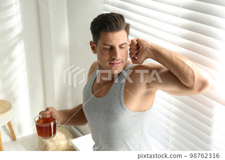 Man with cup of tea near window. Lazy morning 98762316